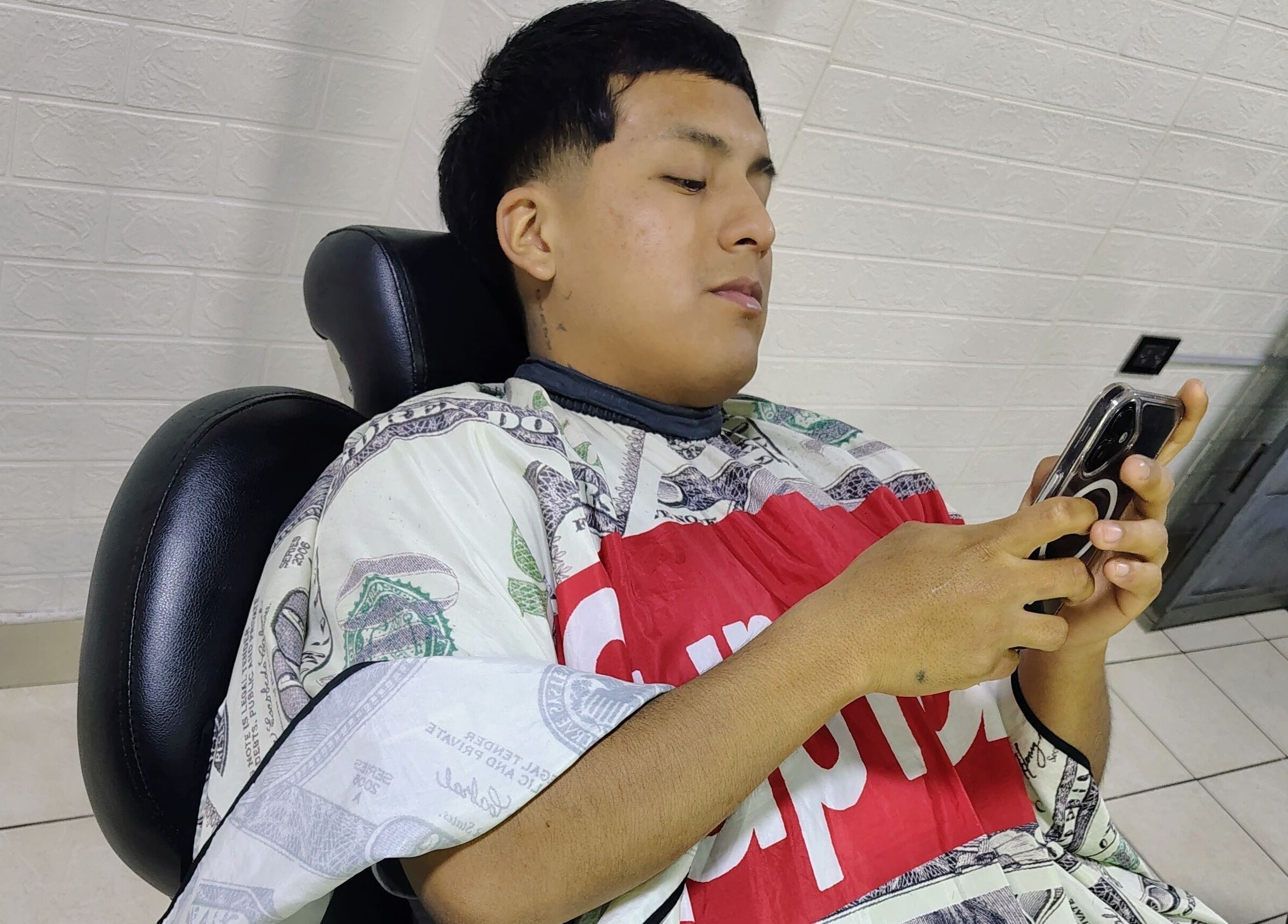 Cliente relajado en Barber E Fac, San Juan De Lurigancho, Provincia De Lima, PE, disfrutando de un corte moderno.