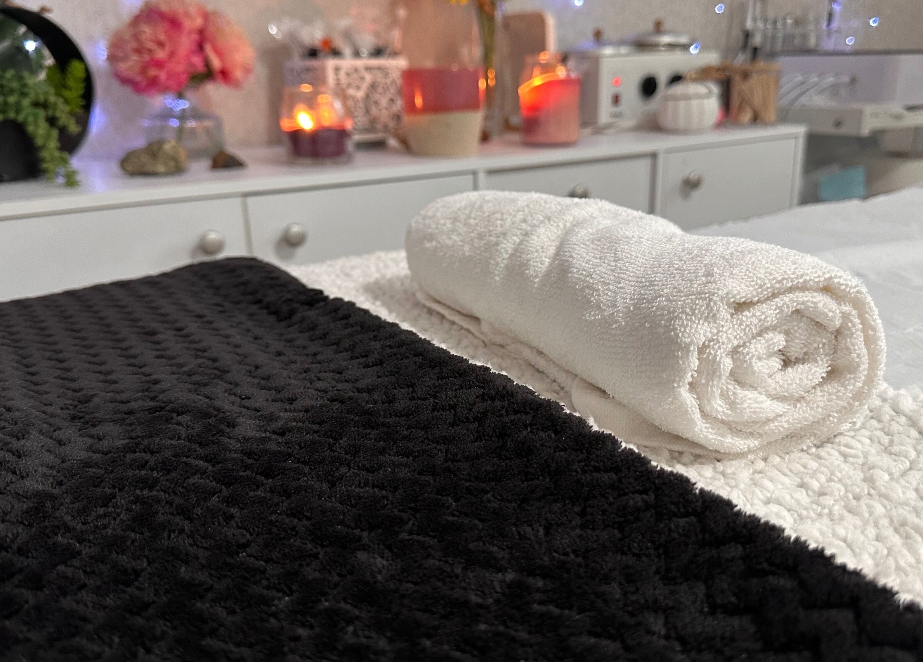 Andi’s Beauty Room, Lurgan, elegáns fehér és fekete törölközők a wellness szobában.