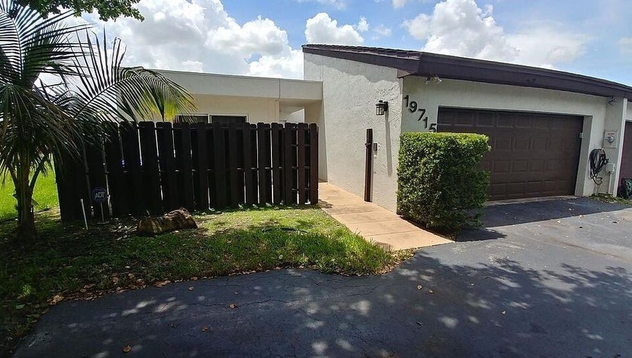 Entrance of Polished by Meg, Country Club, Florida, showcasing modern exterior with tropical landscaping.