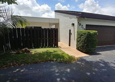 Entrance of Polished by Meg, Country Club, Florida, showcasing modern exterior with tropical landscaping.