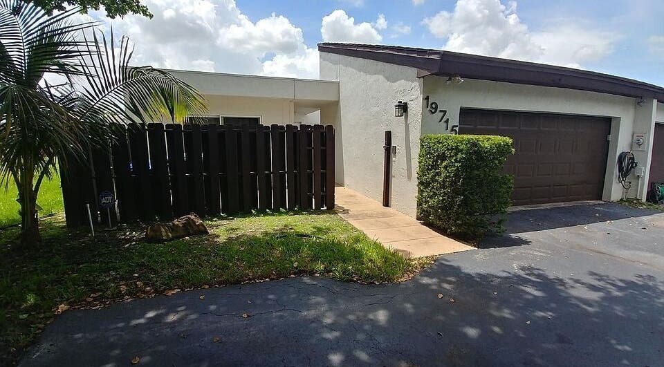 Entrance of Polished by Meg, Country Club, Florida, showcasing modern exterior with tropical landscaping.