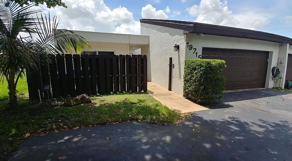 Entrance of Polished by Meg, Country Club, Florida, showcasing modern exterior with tropical landscaping.
