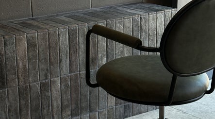 Elegant salon chair and modern stone wall at Atelier Annelise, Port Kembla, New South Wales, AU.