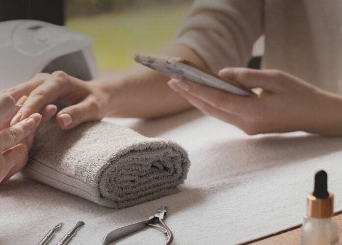 Manicure session at Seven Cures, Riyadh. Hands on towel with manicure tools in the spa.