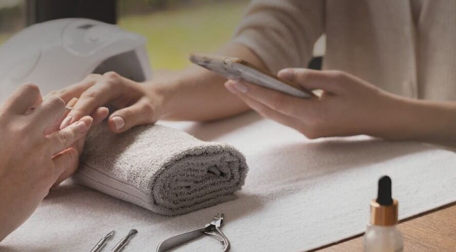 Manicure session at Seven Cures, Riyadh. Hands on towel with manicure tools in the spa.