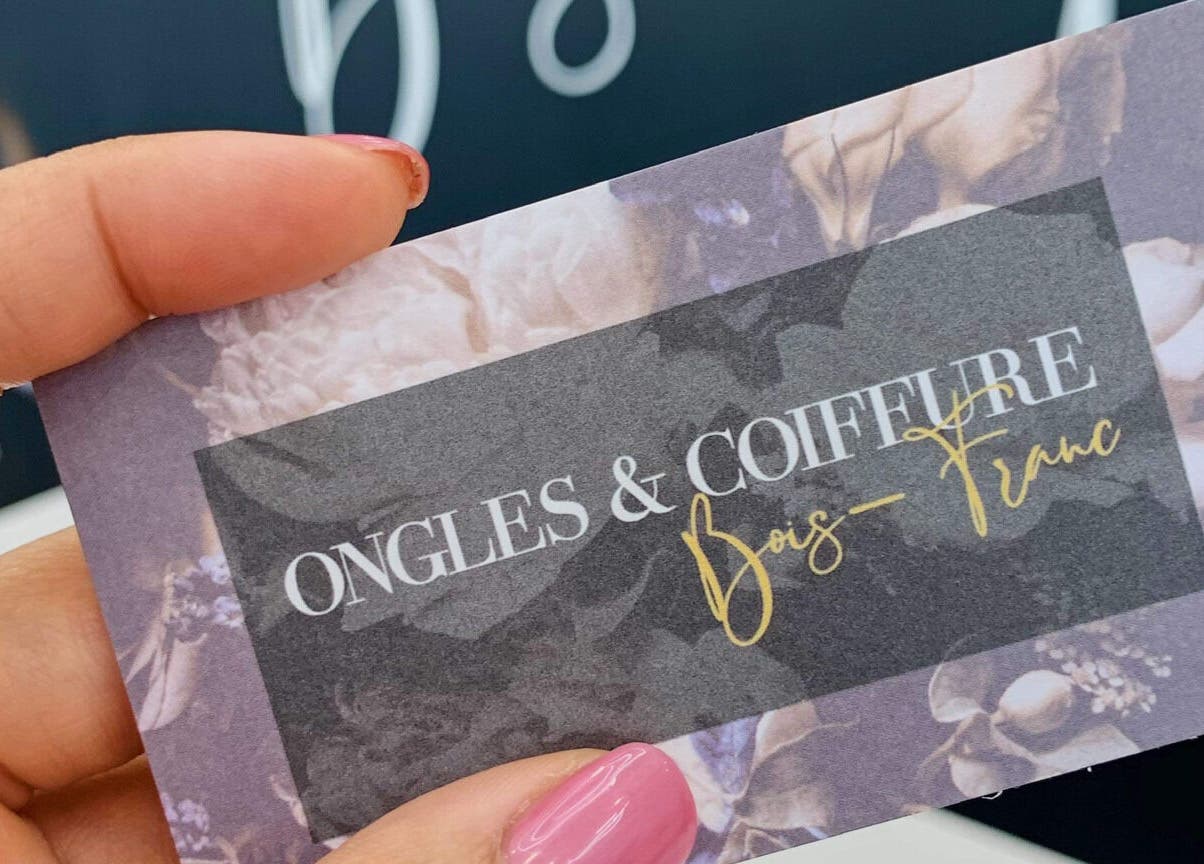 Carte de Ongles & Coiffure Bois-Franc à Montreal, Québec, CA, tenue par une main avec ongles roses élégants.