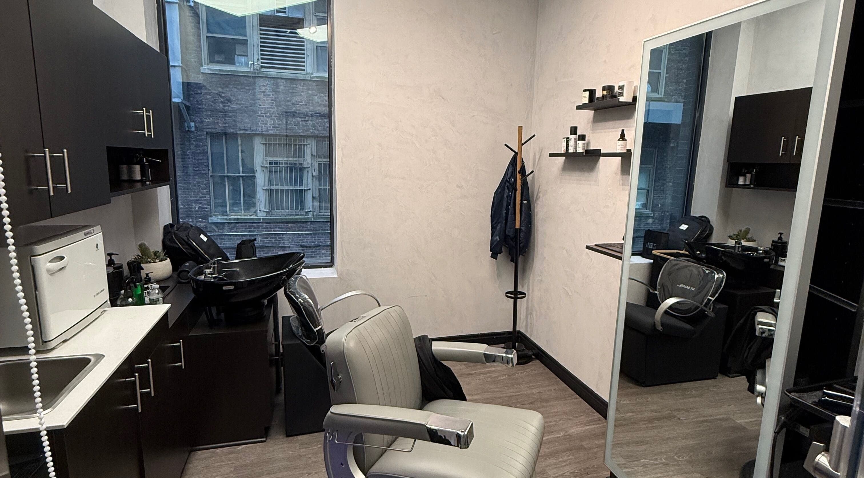 Stylish salon room at Savant Midtown in New York with modern chair and mirror setup.