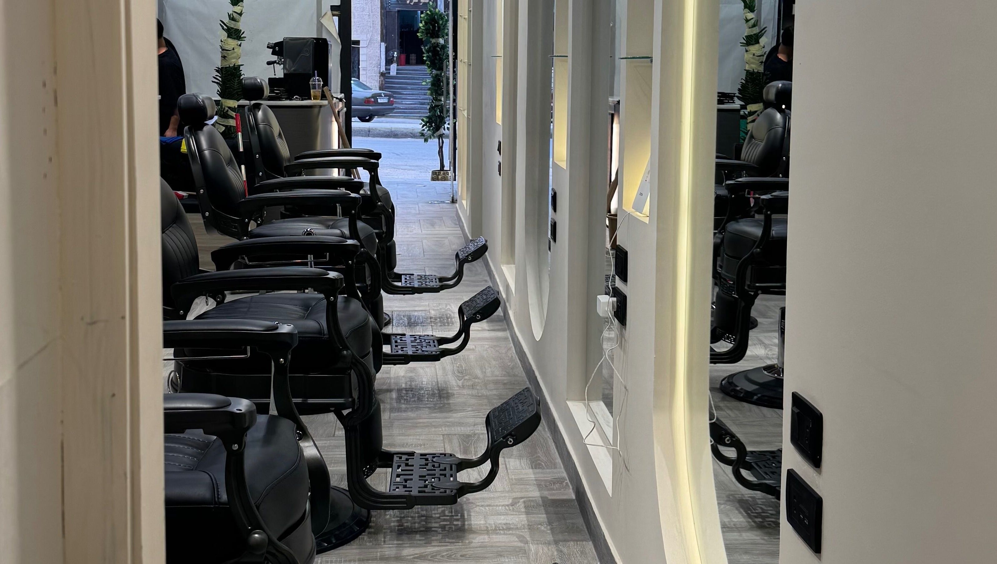 كراسي الحلاقة في صالون Bee Cut في الزرقاء، محافظة الزرقاء، JO بإضاءة راقية وتصميم حديث.