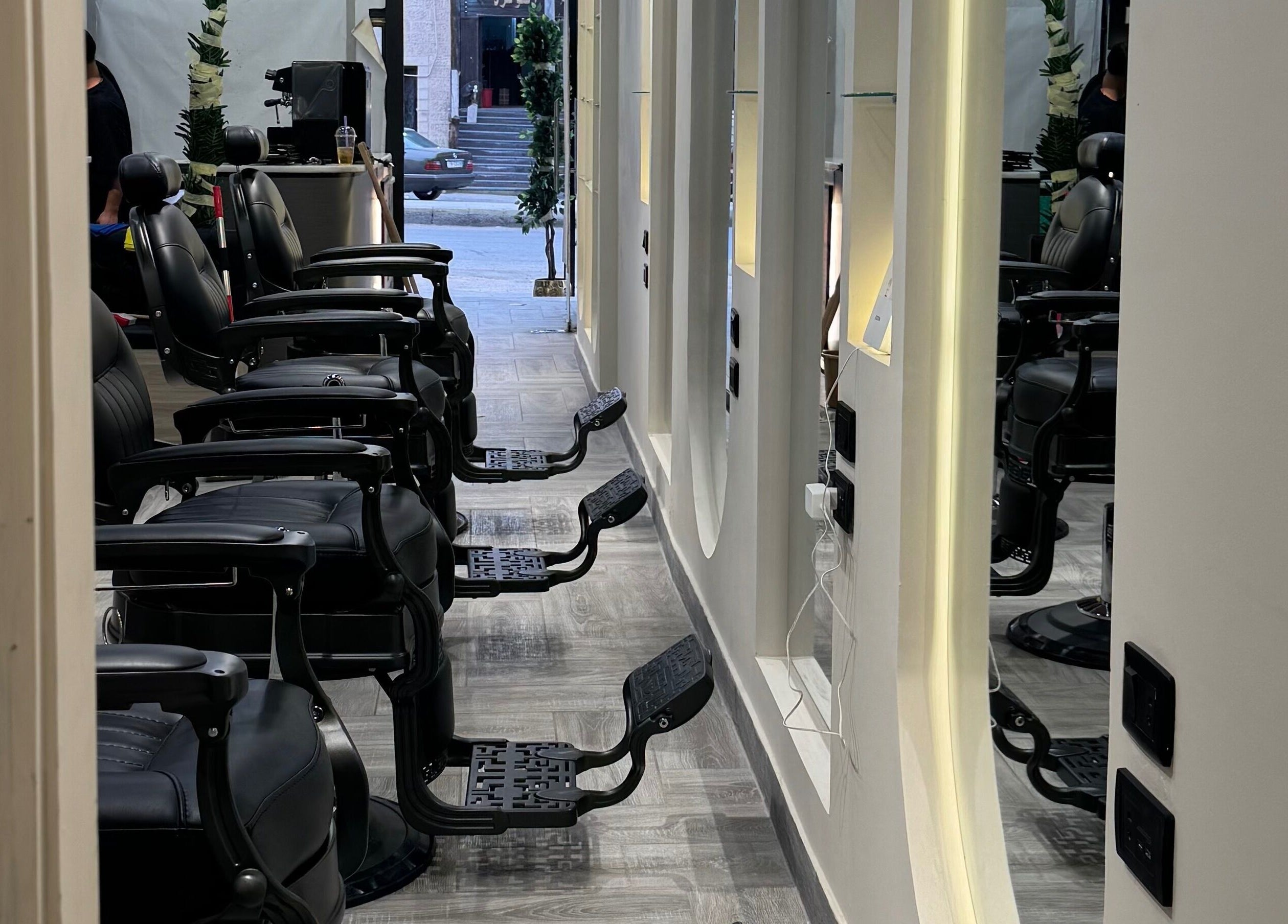 كراسي الحلاقة في صالون Bee Cut في الزرقاء، محافظة الزرقاء، JO بإضاءة راقية وتصميم حديث.