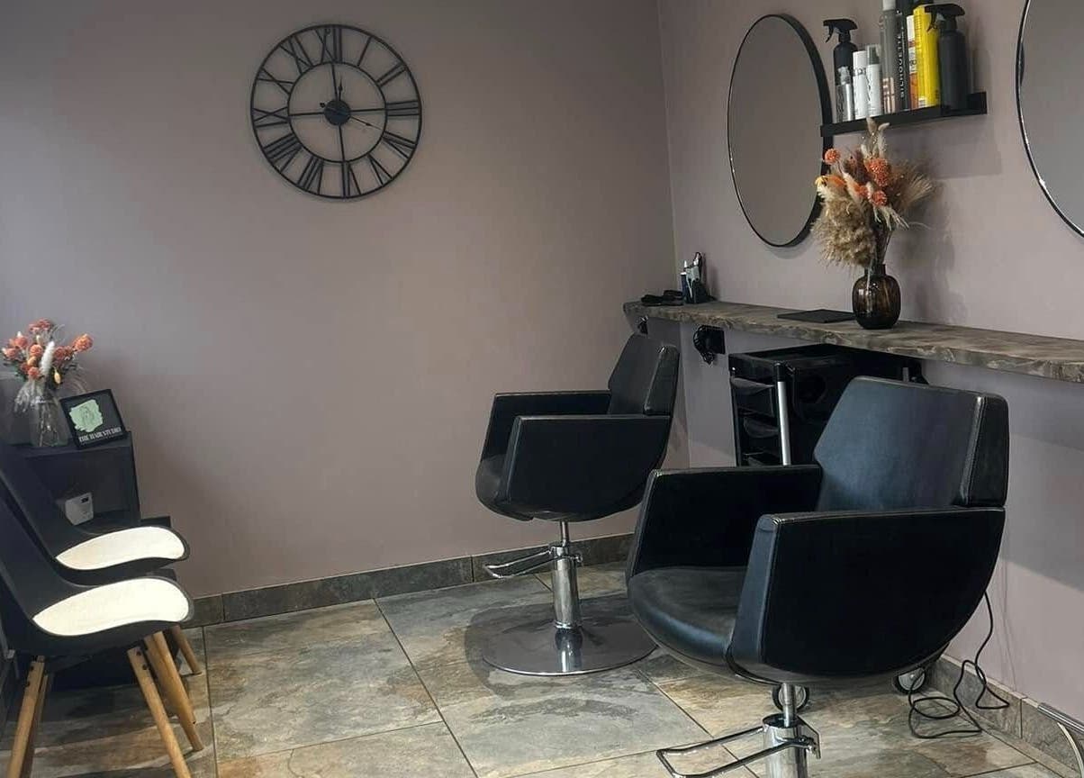 Modern salon setup at The Hair Studio in Ellesmere Port, England, GB featuring stylish chairs and decor.