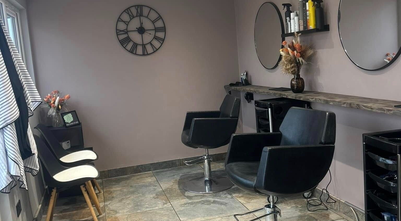 Modern salon setup at The Hair Studio in Ellesmere Port, England, GB featuring stylish chairs and decor.