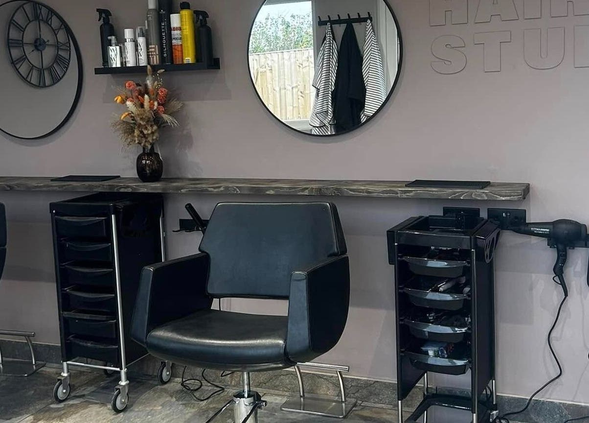 Modern salon interior at The Hair Studio in Ellesmere Port, England, GB with styling chairs and mirrors.