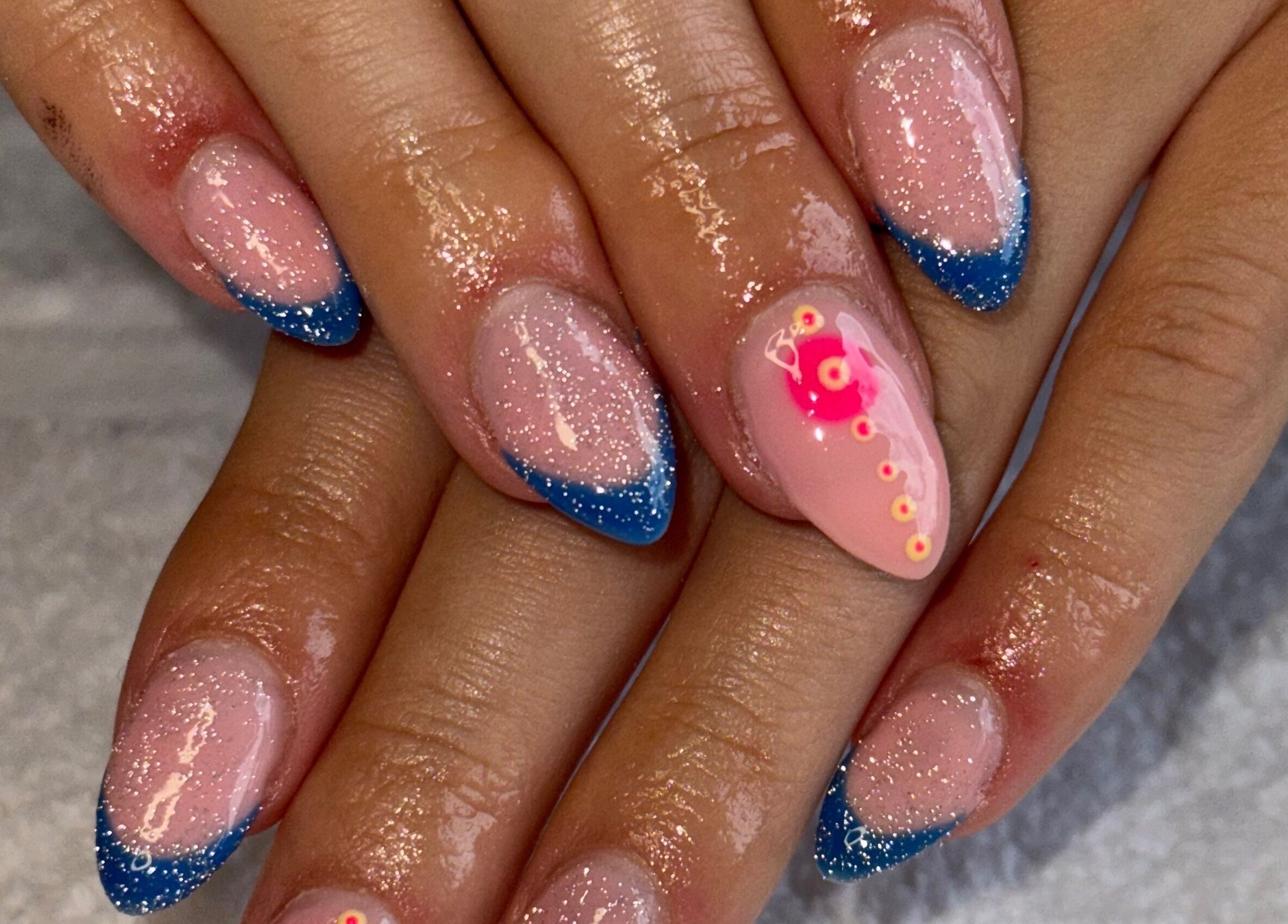 Sparkling nails with blue tips and pink accents at Nails by Nell, Hawthorn, England, GB.