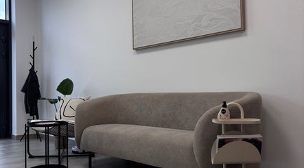 Elegantní posezení ve studiu.bbx, Plzeňský Kraj, CZ s moderní pohovkou a uměním na zdi.