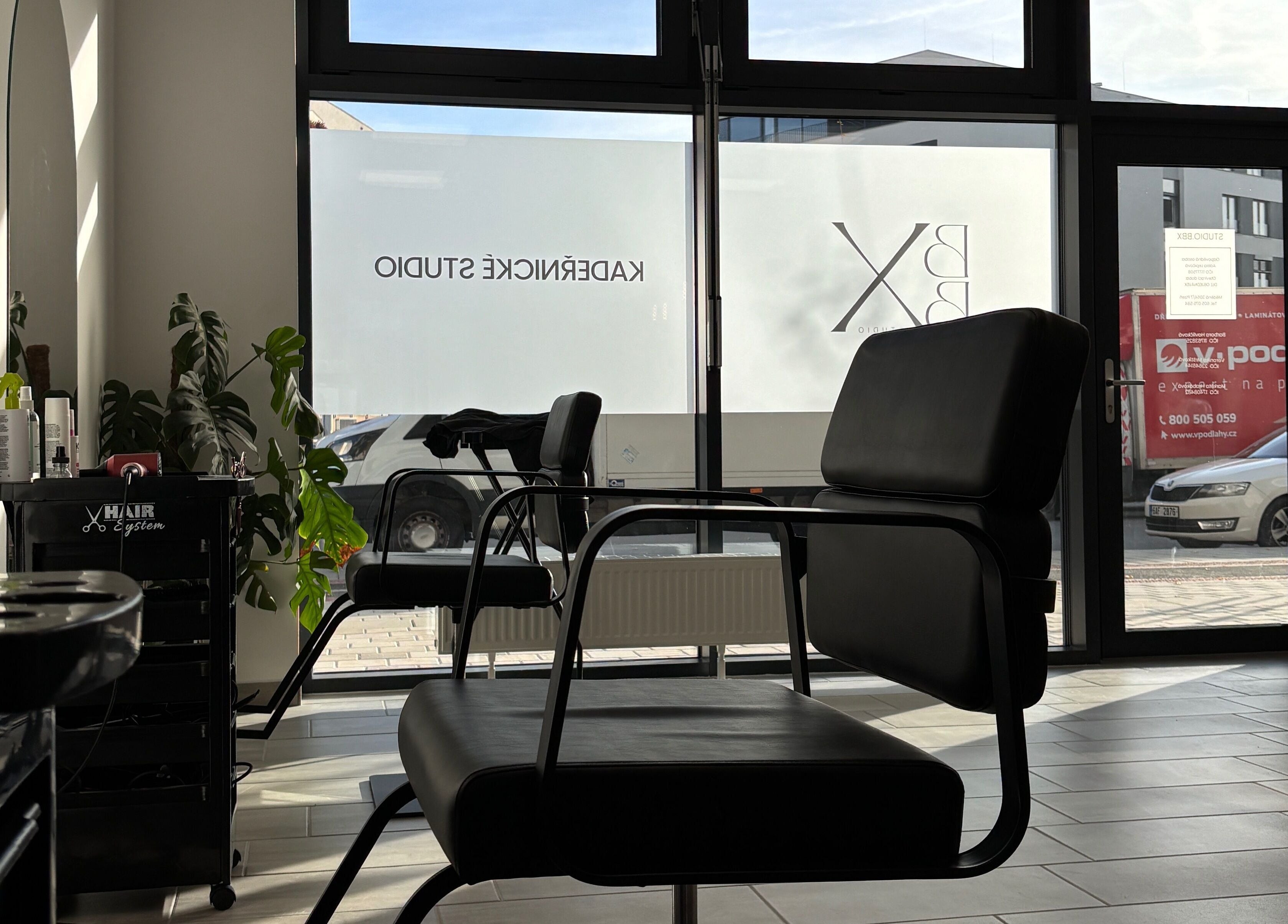 Interiér Studio.bbx v Plzeňském Kraji, pohodlné kadeřnické křeslo osvícené přirozeným světlem.