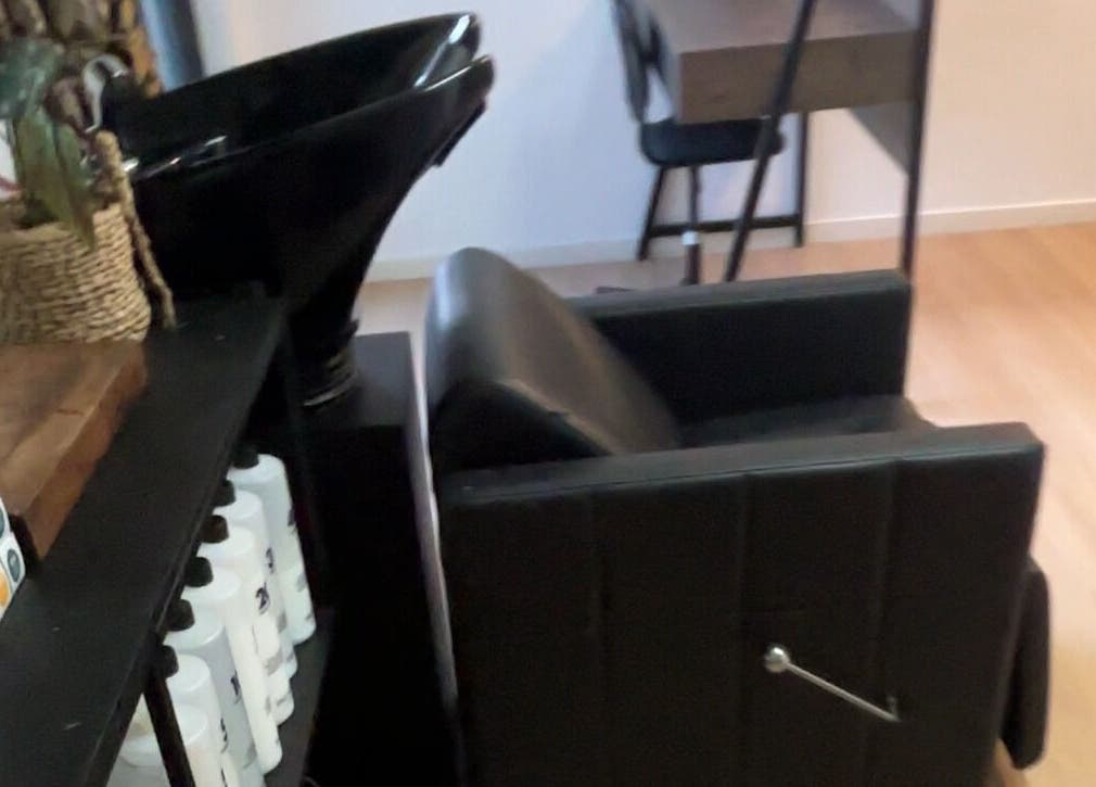 Elegant hair salon station at ZÜS, Ormeau, Queensland, AU featuring a sleek black chair and modern basin.