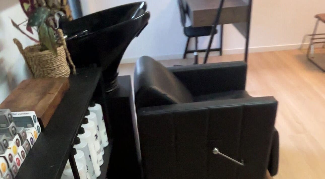 Elegant hair salon station at ZÜS, Ormeau, Queensland, AU featuring a sleek black chair and modern basin.