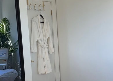 Calm therapy room at Palm Laser in Holsworthy, New South Wales, AU with a robe and palm plant decor.