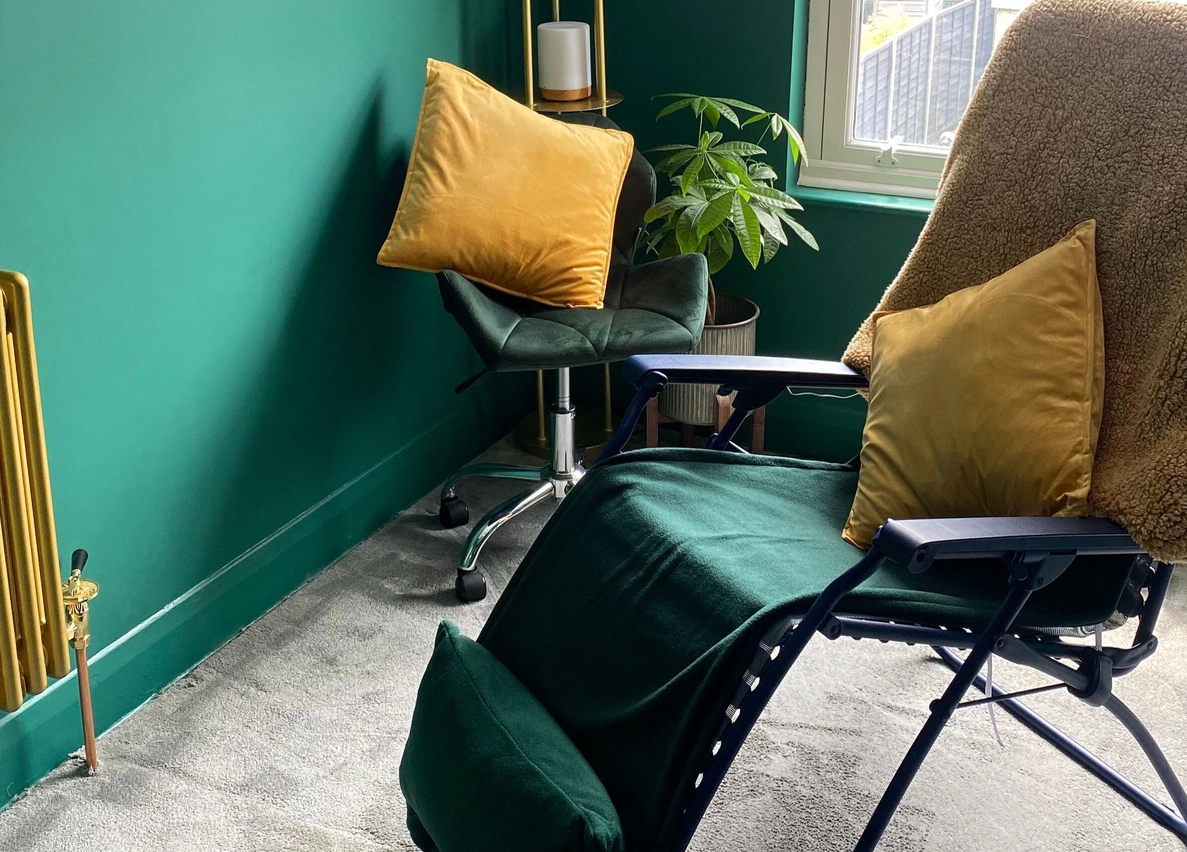 Relaxing room at Heeling Palms Reflexology & Holistic Health, Fareham, England, GB with plush chairs and green decor.