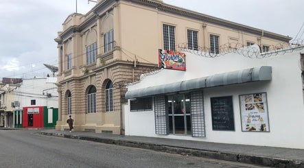 Street view of Alleviate Beauty Bar, Port of Spain, showcasing elegant architecture and inviting entrance.