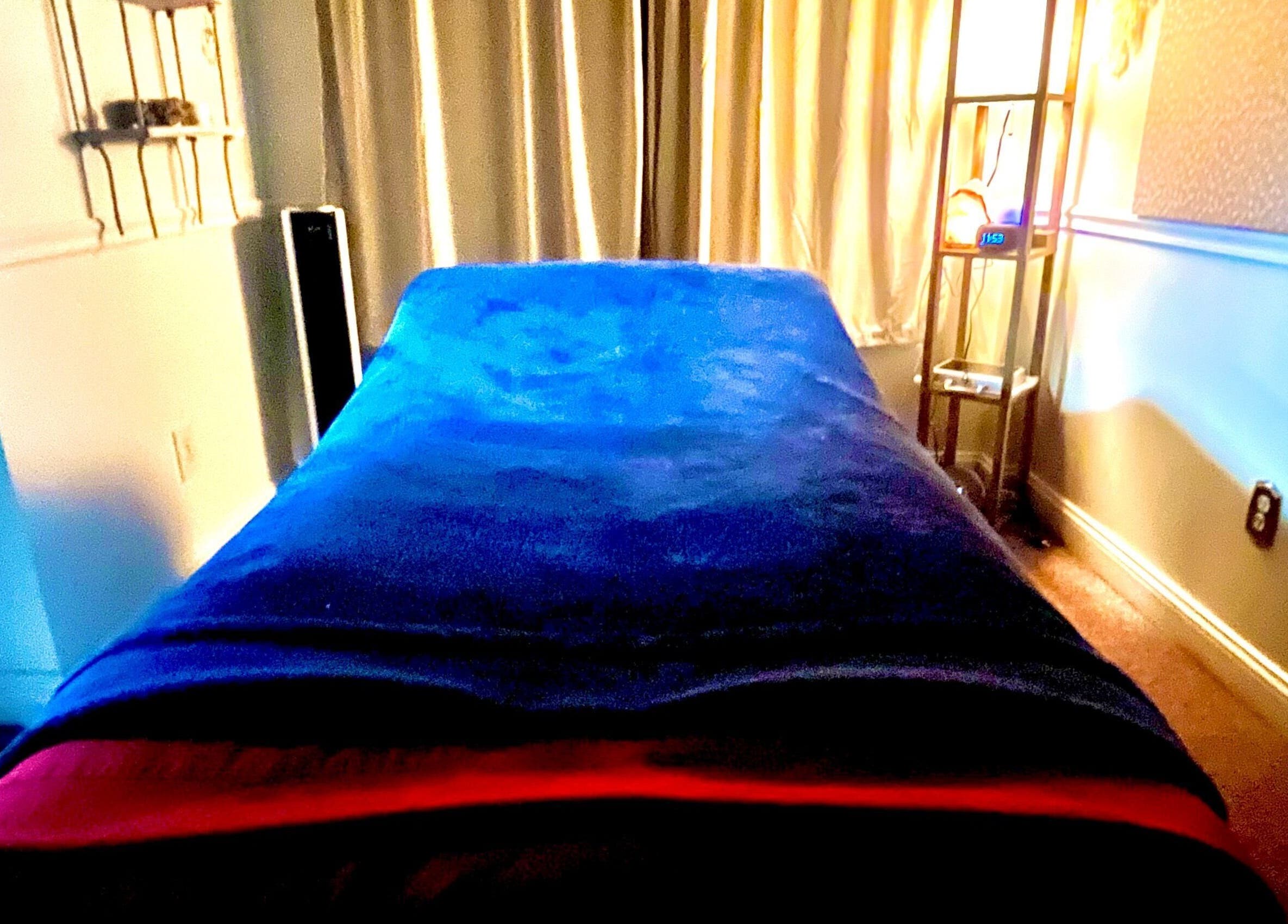 Relaxing massage room at Kristin Palano, South Hadley, Massachusetts, US, with blue plush cover and soft lighting.