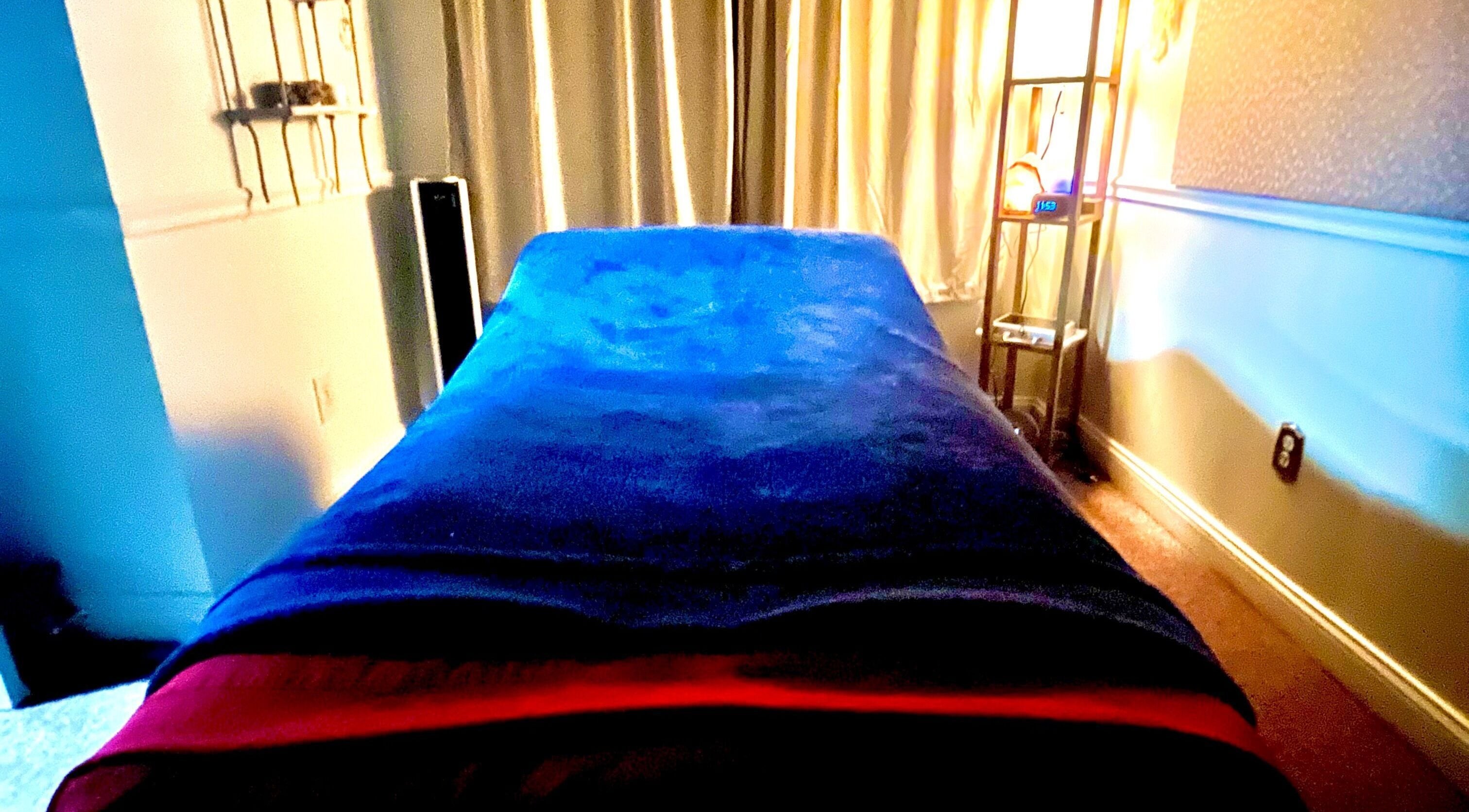 Relaxing massage room at Kristin Palano, South Hadley, Massachusetts, US, with blue plush cover and soft lighting.