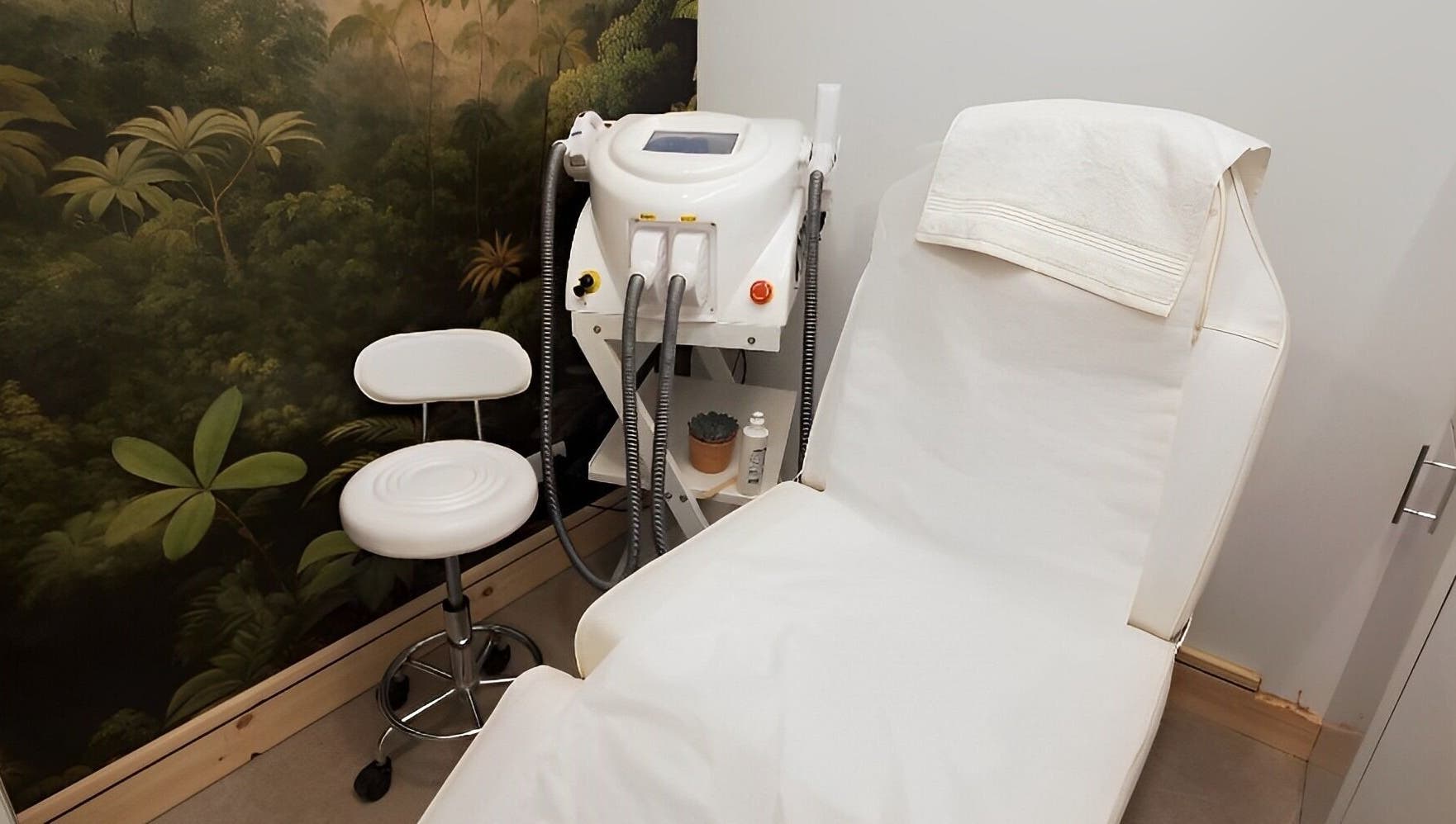 Relaxing treatment room at Miah’s Aesthetics, Eastbourne, England with chair and equipment for wellness care.