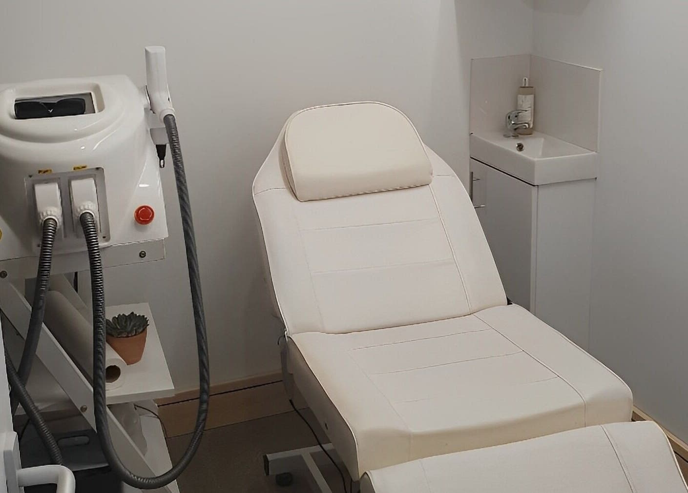 Treatment room at Miah’s Aesthetics, Eastbourne, England, GB featuring a white therapy bed and modern equipment.