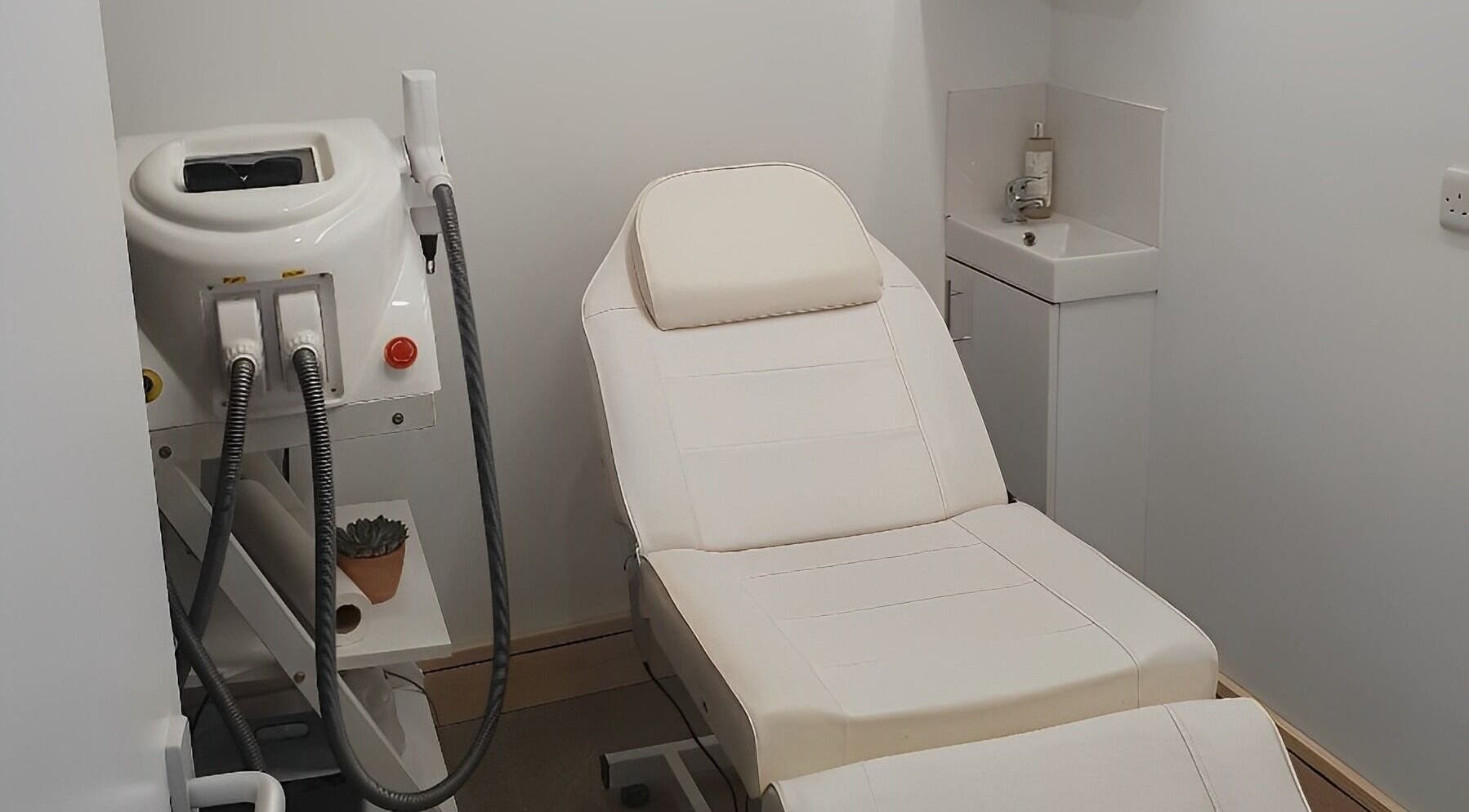 Treatment room at Miah’s Aesthetics, Eastbourne, England, GB featuring a white therapy bed and modern equipment.