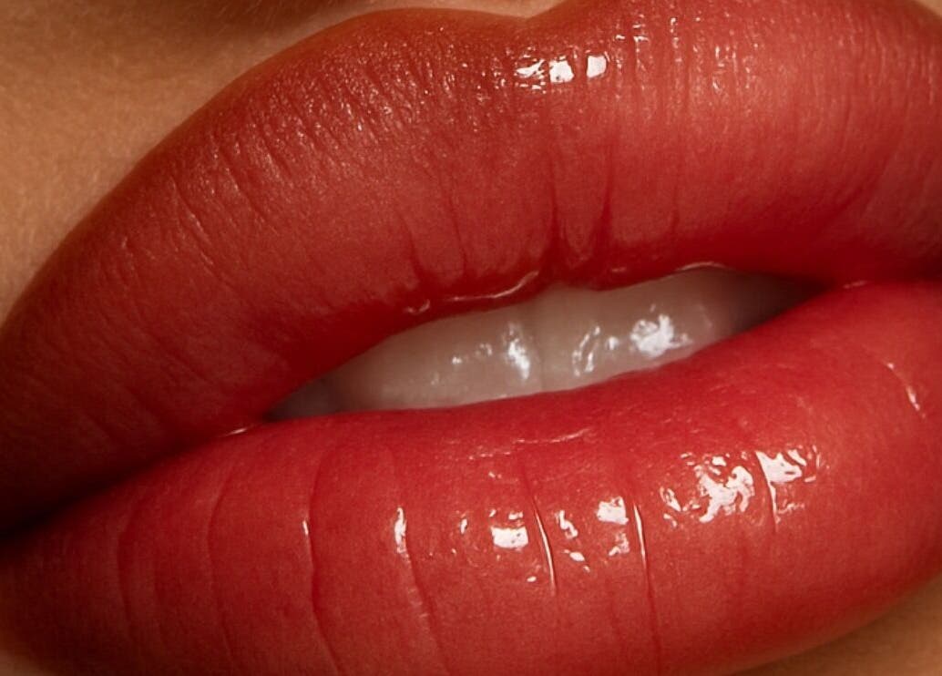 Vibrant red lips with gloss, showcasing beauty services at EnhancedbyMursal, Toronto, Ontario, CA.