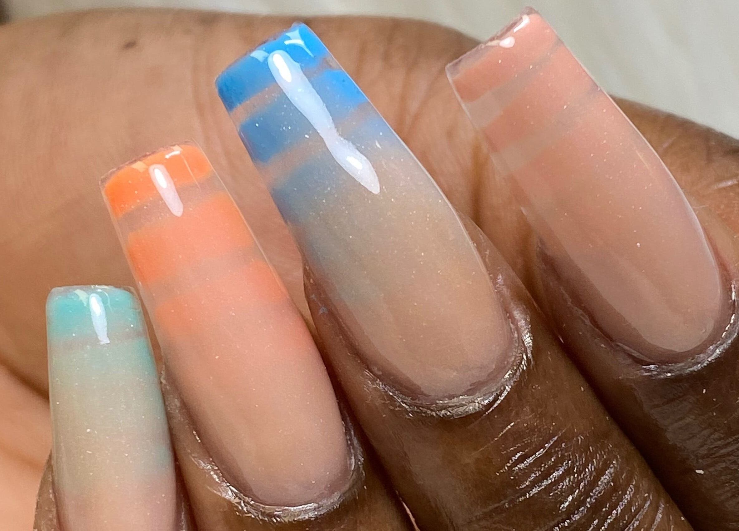 Elegant ombre nail art at Acacias Nails By JC in Toronto, Ontario, CA, with vibrant orange and blue hues.
