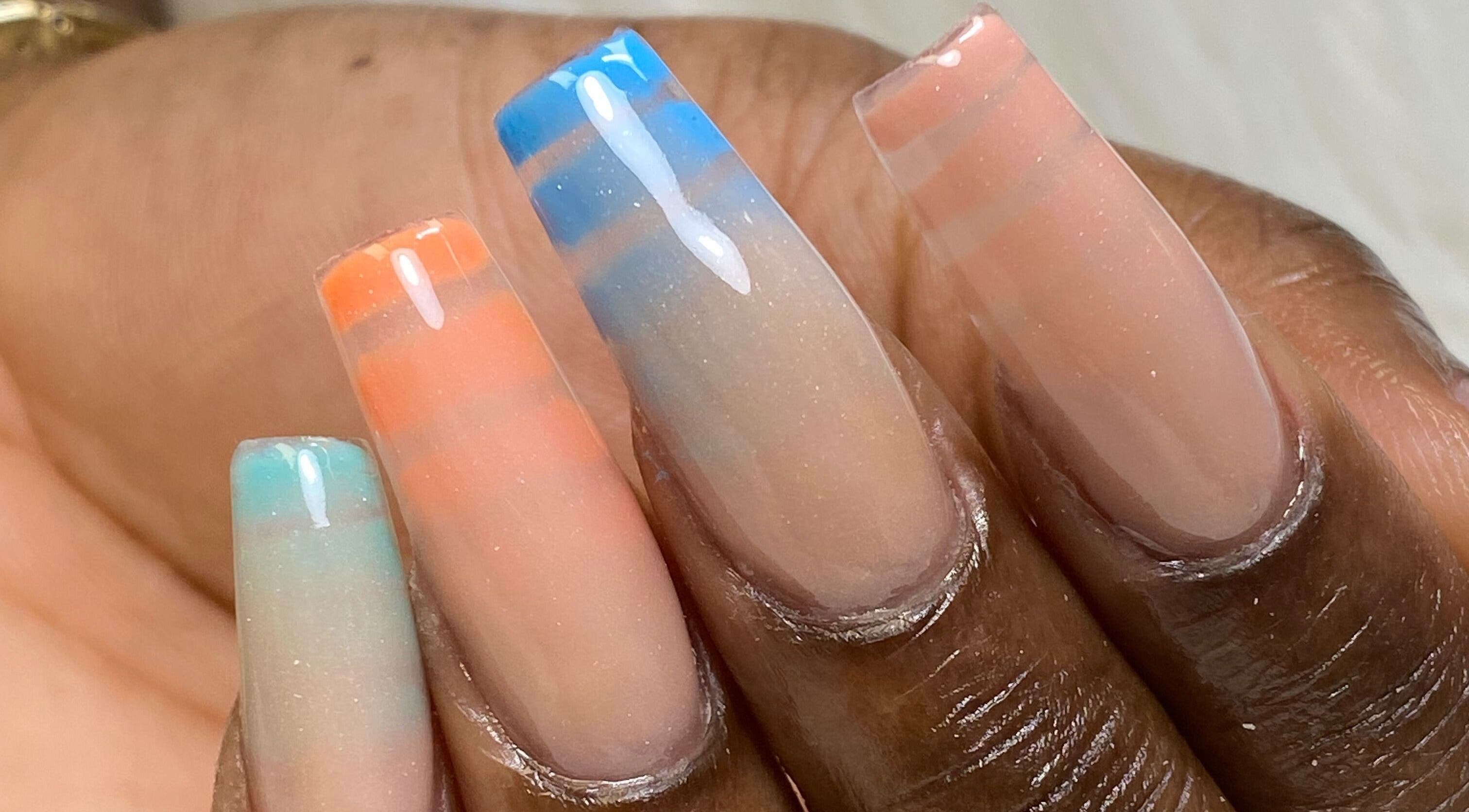 Elegant ombre nail art at Acacias Nails By JC in Toronto, Ontario, CA, with vibrant orange and blue hues.