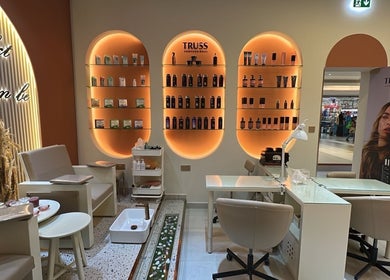 Interior of Flair Beauty Salon in دبي, دبي, AE with stylish shelving and cozy seating.