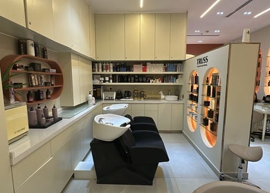 Modern interior of Flair Beauty Salon in دبي, دبي, AE with sleek shelves, chairs, and beauty products on display.