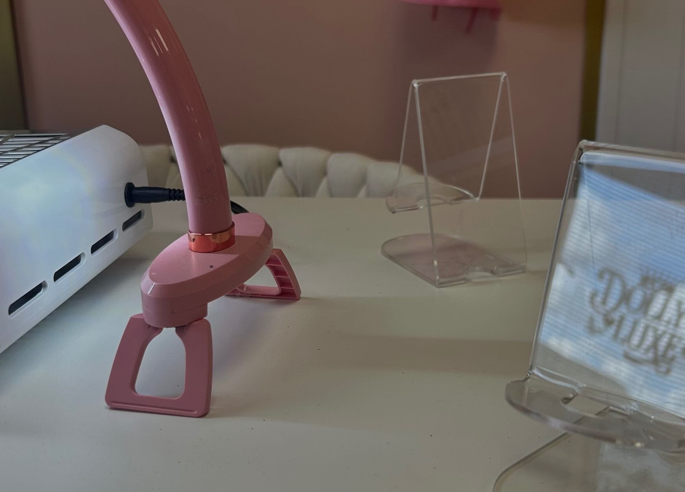 A nail station at Triple A Nails in Dumbarton, Scotland, featuring a pink lamp and manicure equipment.