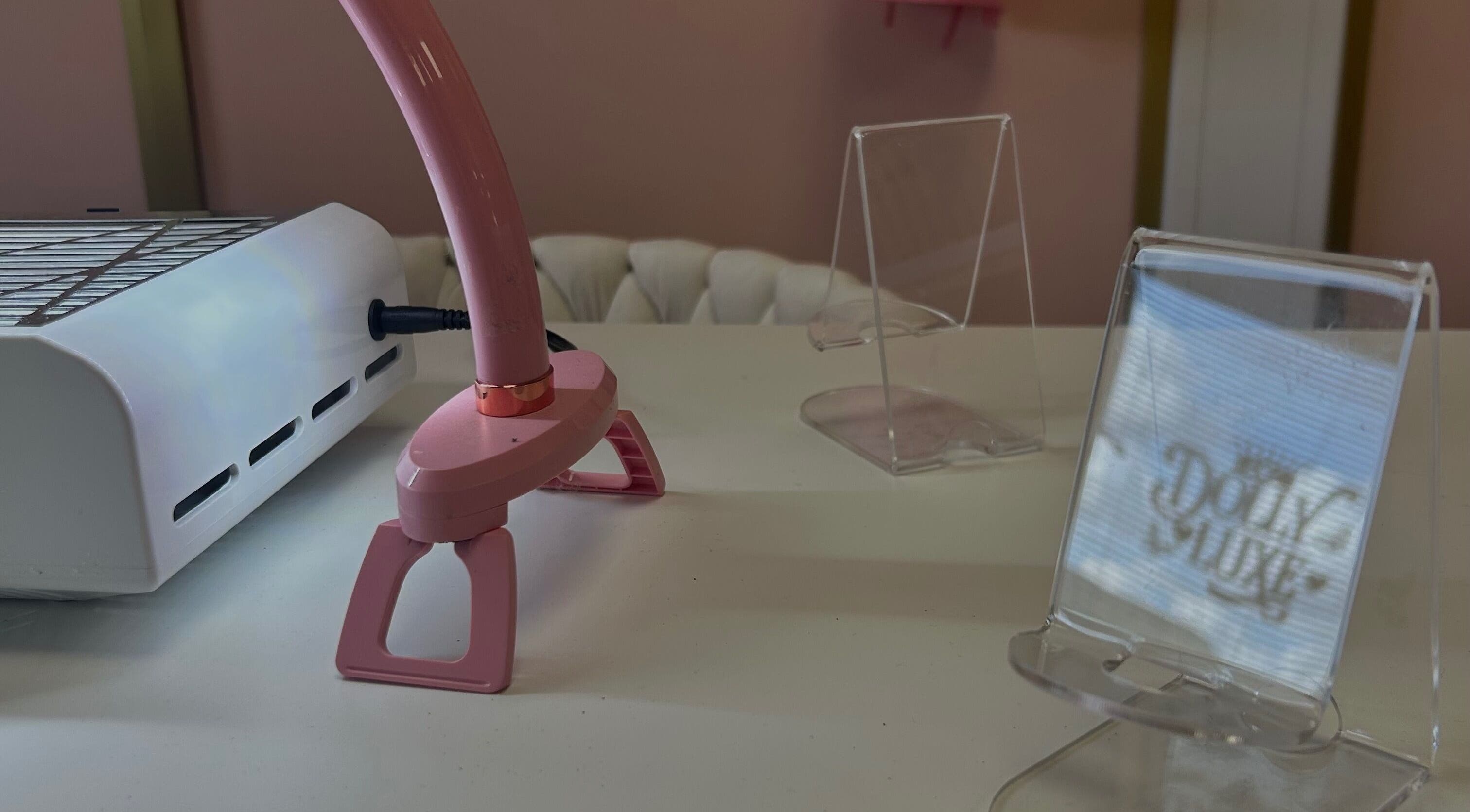 A nail station at Triple A Nails in Dumbarton, Scotland, featuring a pink lamp and manicure equipment.