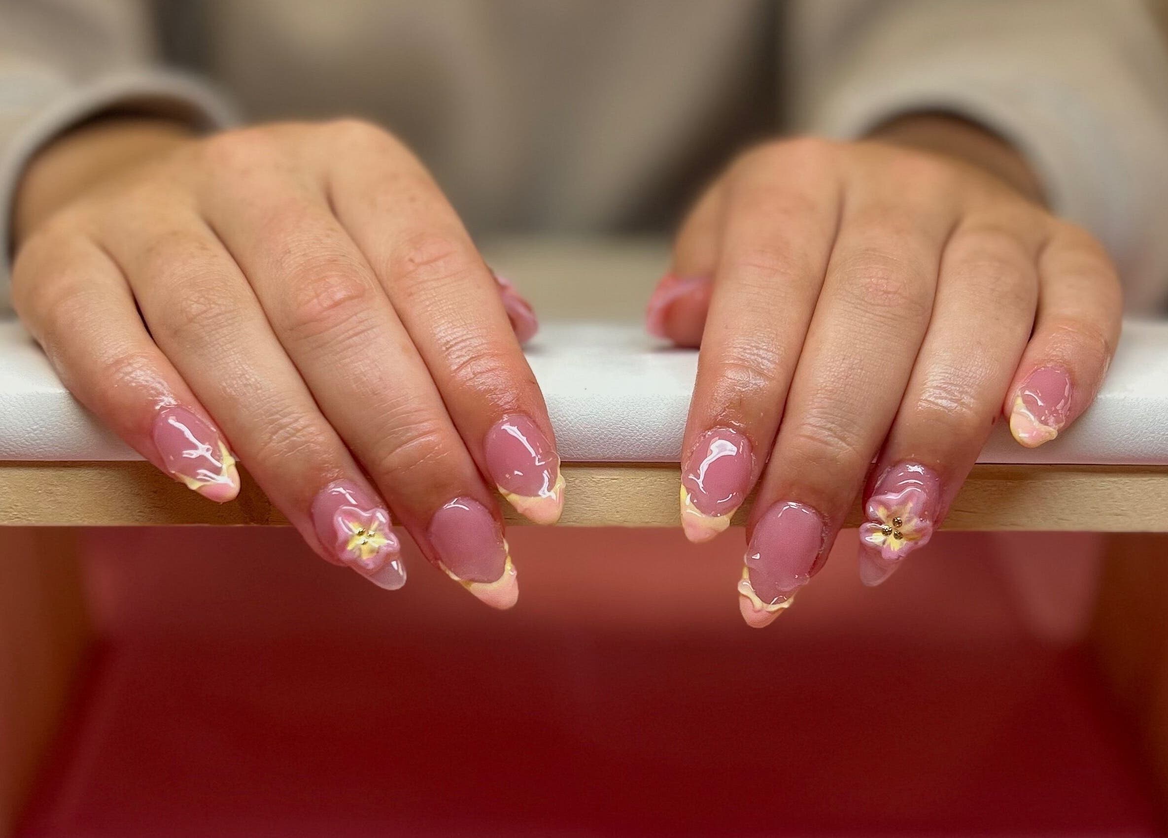 Elegant floral pink nails at Triple A Nails in Dumbarton, Scotland, GB provide a chic manicure experience.