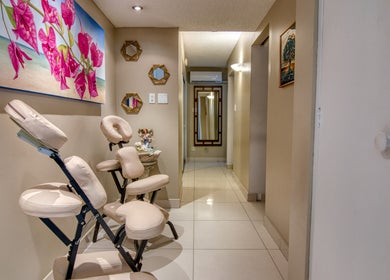 Inviting hallway at 108 Aquarius Spa, Simpson Bay, SX, featuring massage chairs and vibrant floral artwork.