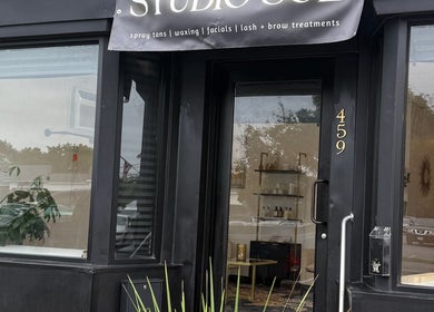 Front entrance of Studio Sol in Farmingdale, New York, US, showcasing elegant glass door and signage.