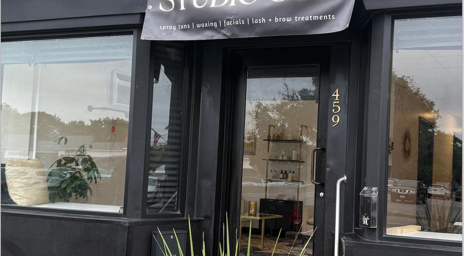 Front entrance of Studio Sol in Farmingdale, New York, US, showcasing elegant glass door and signage.