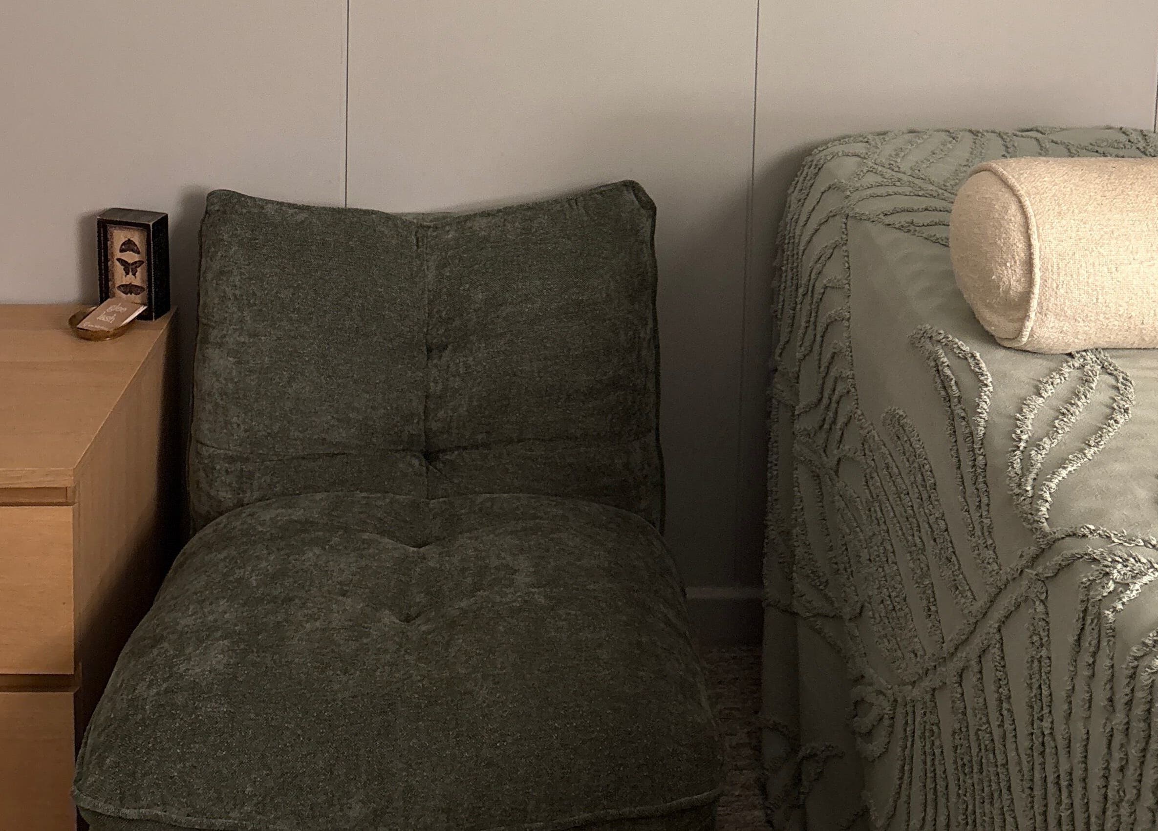 Cozy massage room at Glee Lash, Koongamia, Western Australia, AU with a plush chair and wooden side table.