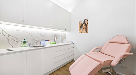 Lueur Clinic treatment room in North Willoughby, New South Wales, AU with pink chair and modern decor.