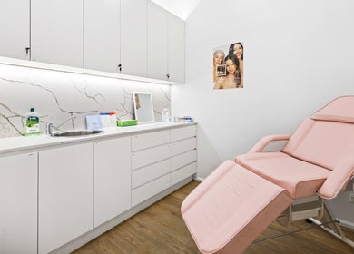 Lueur Clinic treatment room in North Willoughby, New South Wales, with a pink chair and modern decor.