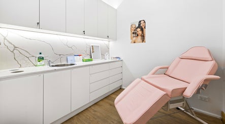 Lueur Clinic treatment room in North Willoughby, New South Wales, with a pink chair and modern decor.
