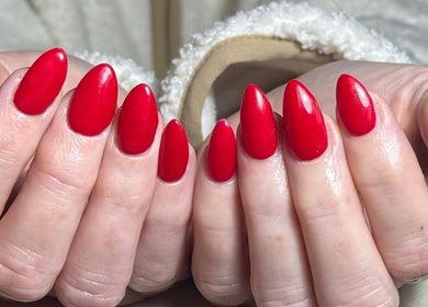 Bright red manicured nails showcasing artistry at The Beauty Hut, Bourne, England, GB.