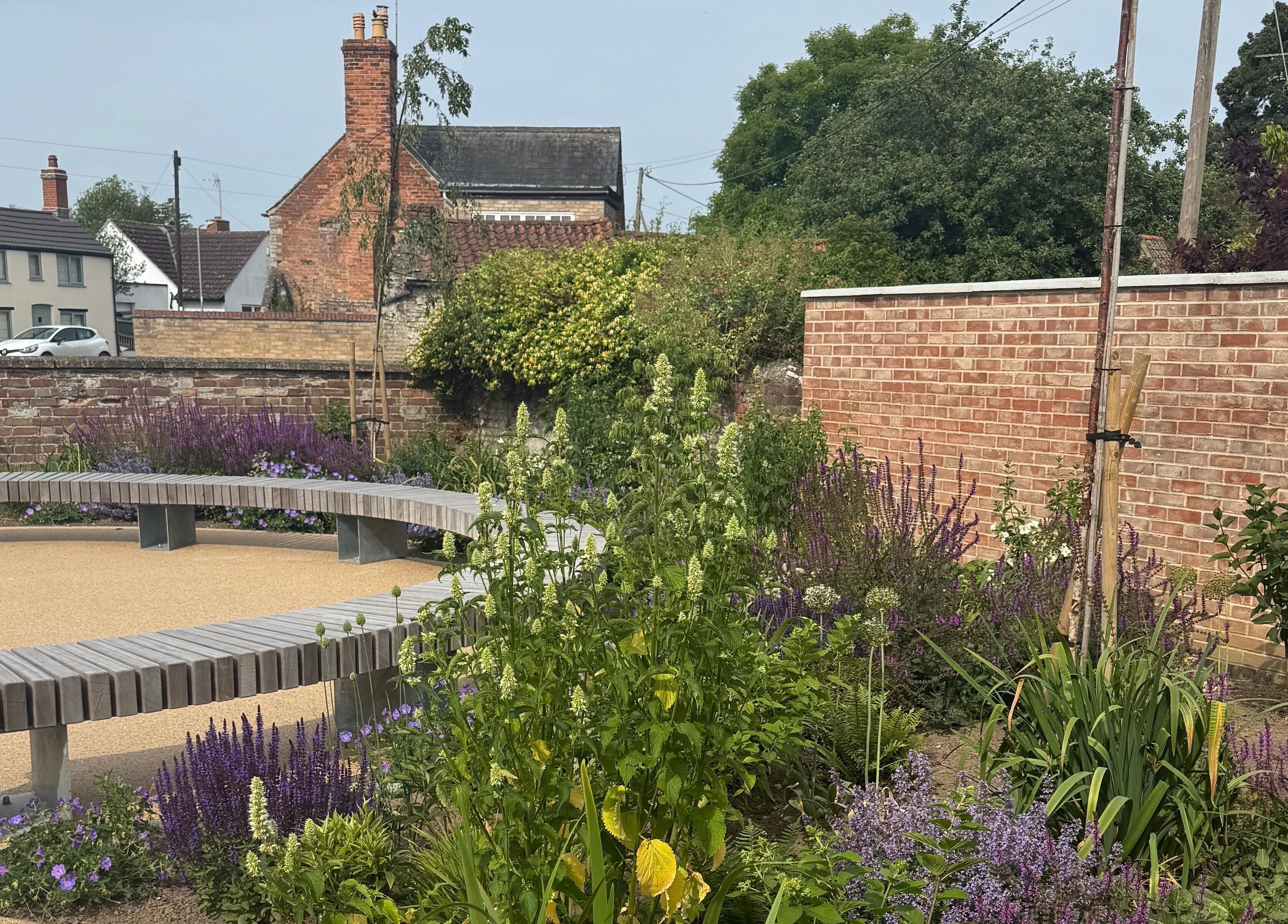 Beautiful garden view at The Beauty Studio, Peterborough, England, GB, featuring lush plants and a brick wall.