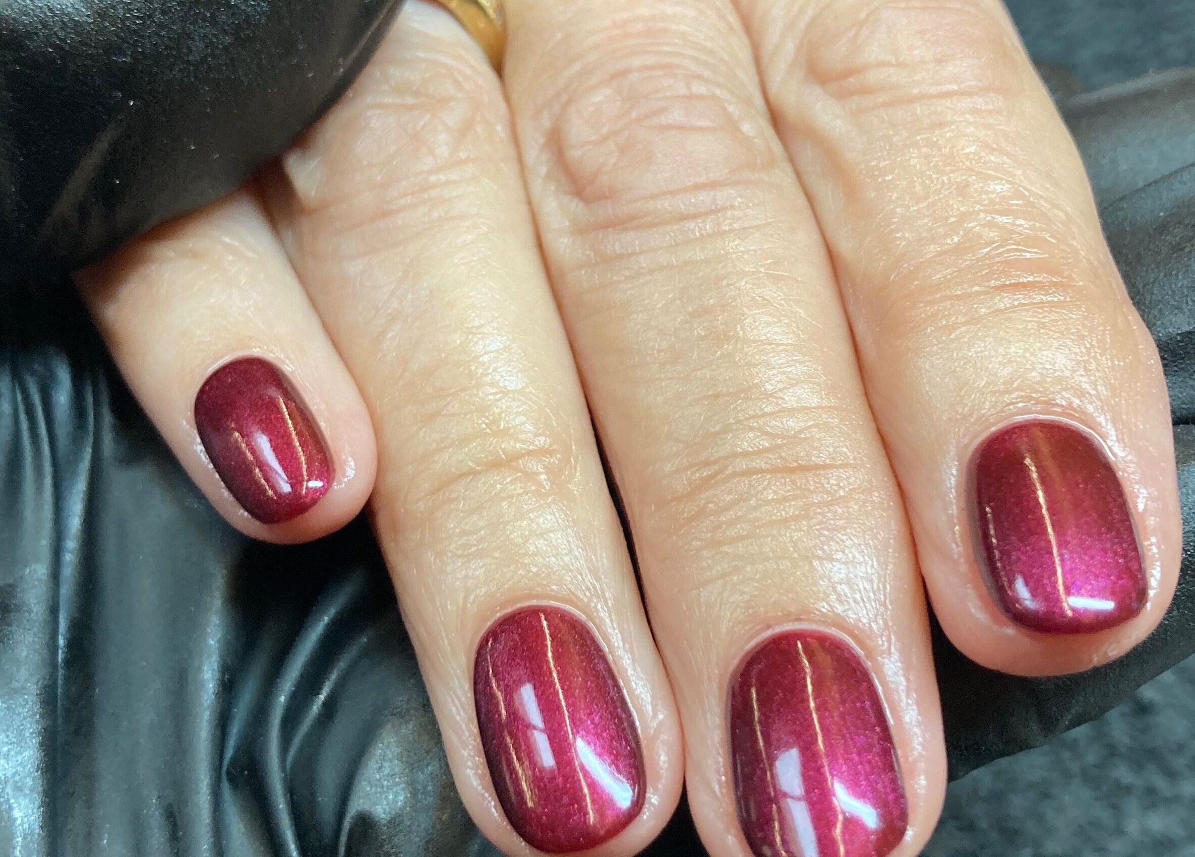 Close-up of glossy crimson nails at The Beauty Studio, Peterborough, England, GB.