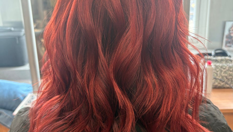Stunning red wavy hairstyle at Hair By Rose, Worthing, England, GB, showcasing vibrant color and texture.