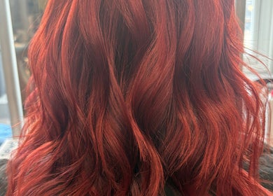 Stunning red wavy hairstyle at Hair By Rose, Worthing, England, GB, showcasing vibrant color and texture.