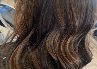 Elegant wavy hairstyle at Hair By Rose in Worthing, England, GB, showcasing rich brown highlights.